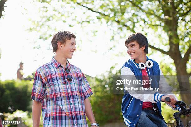 sorridente ragazzi adolescenti con bicicletta - two young boys foto e immagini stock