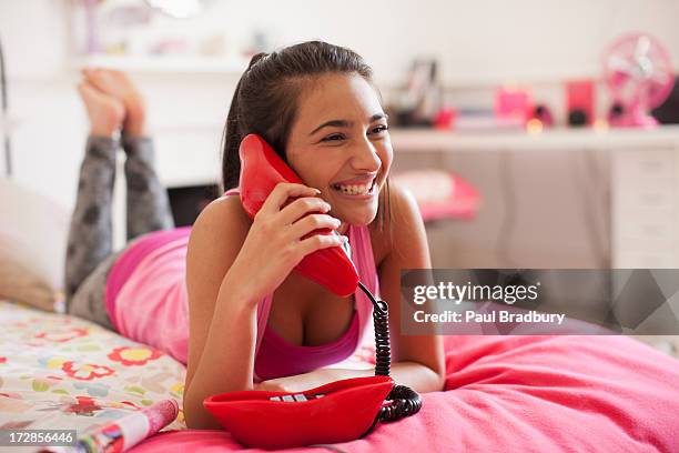 teenage girl talking on telephone in bedroom - teen girl barefoot stock pictures, royalty-free photos & images