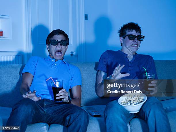 teenage boys watching scary movie - boy at television stockfoto's en -beelden