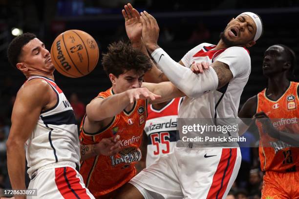 Taran Armstrong of the Cairns Taipans has his shot blocked by Johnny Davis of the Washington Wizards as he collides with Daniel Gafford during the...