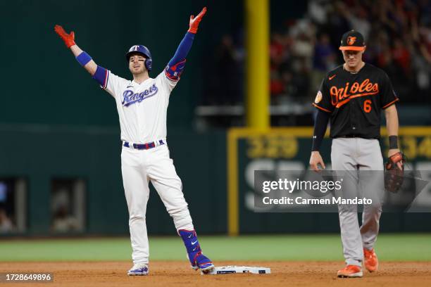 Mitch Garver of the Texas Rangers celebrates after hitting a two-run RBI double against the Baltimore Orioles during the second inning in Game Three...