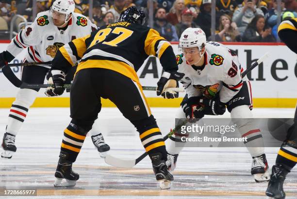 Connor Bedard of the Chicago Blackhawks prepares to face off against Sidney Crosby of the Pittsburgh Penguins during the first period at PPG PAINTS...
