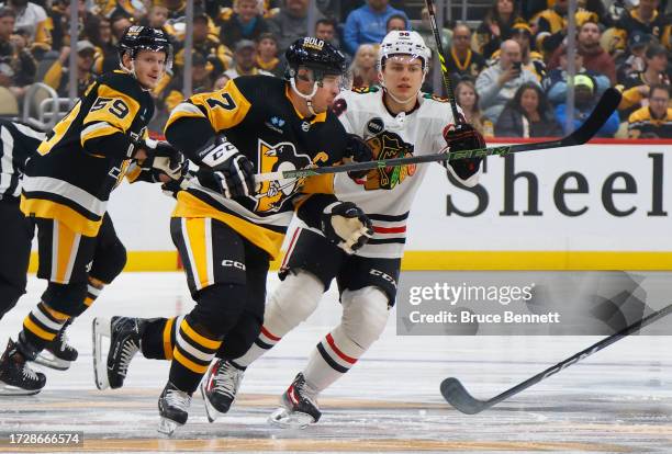 Connor Bedard of the Chicago Blackhawks skates against Sidney Crosby of the Pittsburgh Penguins during the first period at PPG PAINTS Arena on...