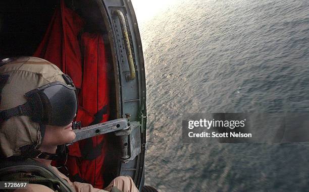 Navy E-5 and helicopter crew chief Stephen Martin from Overland Park, Kansas gazes out into the Persian Gulf January 16 , 2003 during a mission to...