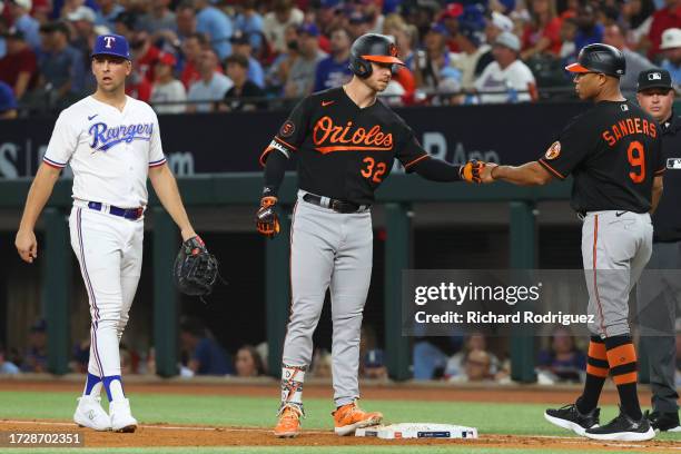 Ryan O'Hearn of the Baltimore Orioles celebrates his single against the Texas Rangers with first base coach Anthony Sanders of the Baltimore Orioles...