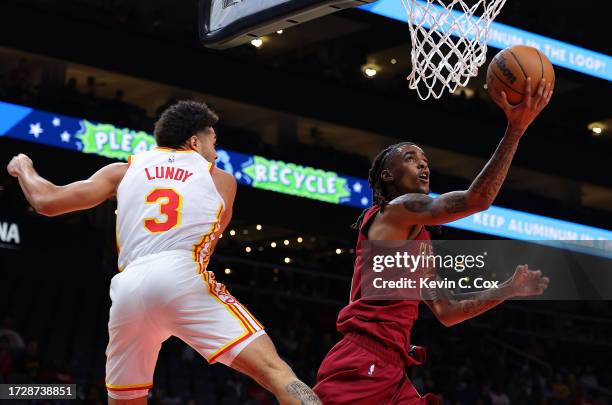 Emoni Bates of the Cleveland Cavaliers drives against Seth Lundy of the Atlanta Hawks during the fourth quarter at State Farm Arena on October 10,...