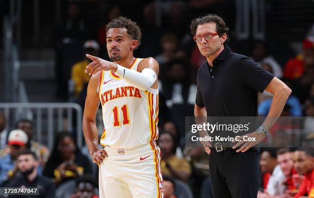 Head coach Quin Snyder and Trae Young of the Atlanta Hawks converse against the Cleveland Cavaliers during the first quarter at State Farm Arena on...