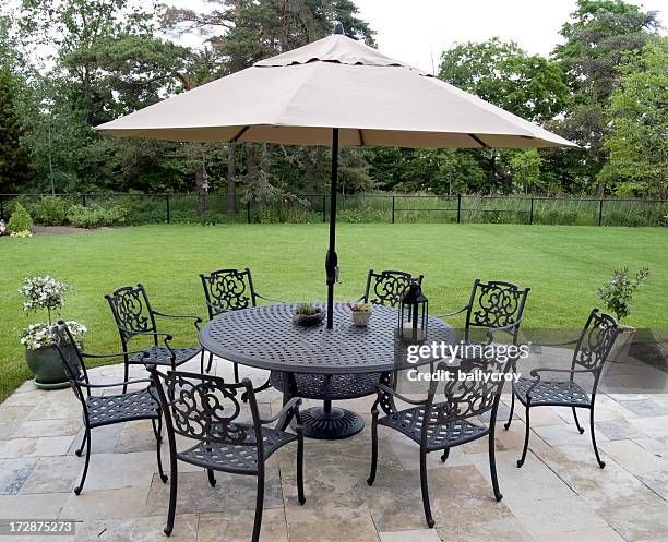 black metal patio furniture set with tan umbrella - garden umbrella stock pictures, royalty-free photos & images