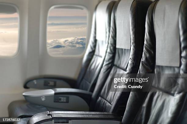 three black aircraft seats looking out of the window - first class plane stockfoto's en -beelden