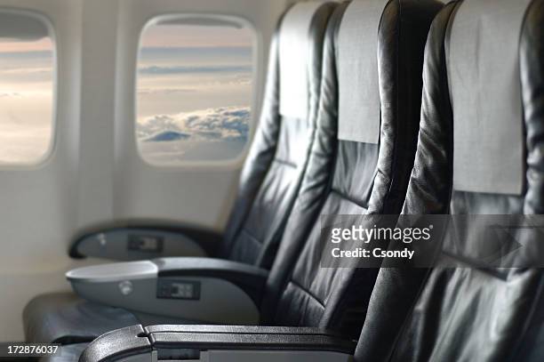 three black aircraft seats looking out of the window - seat stock pictures, royalty-free photos & images