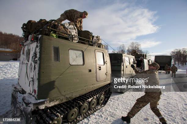 British Royal Marines secure gear atop a BV track vehicle before setting off to exercises March 4, 2013 in the mountains north of the Arctic Circle....