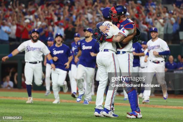 Jose Leclerc and Jonah Heim of the Texas Rangers celebrate after defeating the Baltimore Orioles in Game Three of the Division Series at Globe Life...