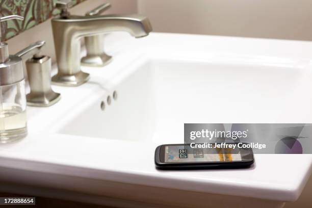 smart phone bathroom sink - verdwaald stockfoto's en -beelden