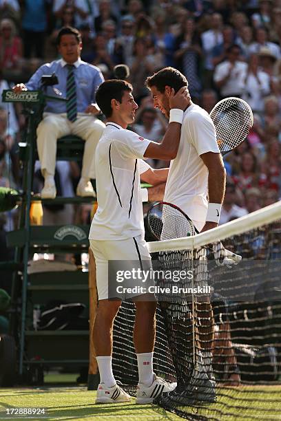 Novak Djokovic of Serbia embraces Juan Martin Del Potro of Argentina at the net after their Gentlemen's Singles semi-final match on day eleven of the...