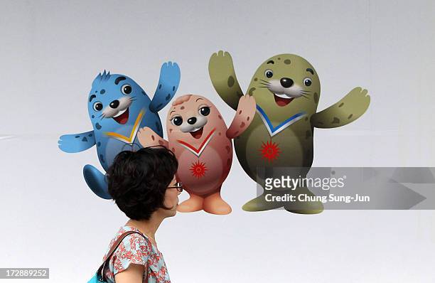 Woman passes in front of the 4th Asian Indoor & Martial Arts Games's mascots picture on July 5, 2013 in Incheon, South Korea.