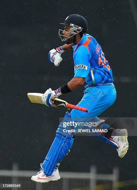 Indian cricket team captain Virat Kohli leaps in the air as he celebrates scoring his century during the fourth match of the Tri-Nation series...