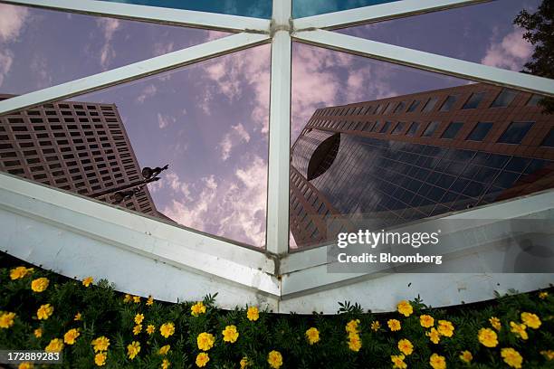 Buildings are reflected in a glass window in Winnipeg, Manitoba, Canada, on Thursday, July 4, 2013. Canada extended the longest streak of merchandise...