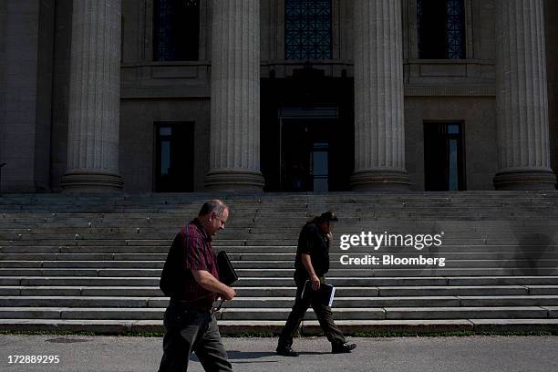 Men walk past the Manitoba Legislative Building in Winnipeg, Manitoba, Canada, on Thursday, July 4, 2013. Canada extended the longest streak of...