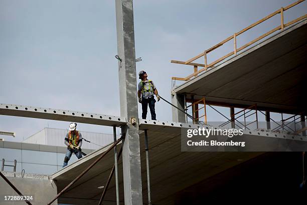 Contractors work on a building under construction in Winnipeg, Manitoba, Canada, on Thursday, July 4, 2013. Canada extended the longest streak of...