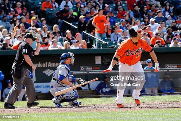 Home plate umpire Marvin Hudson and catcher Ramon Hernandez of the Los Angeles Dodgers look on as Chris Davis of the Baltimore Orioles follows his...