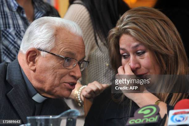 Costa Rican Floribeth Mora --who says she was healed by a miracle attributed to late Pope John Paul II-- cries next to Monsignor Hugo Barrantes...