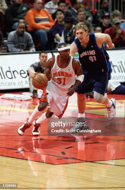 Jason Terry of the Atlanta Hawks drives past Dirk Nowitzki of the Dallas Mavericks during the NBA game at Philips Arena on January 8, 2003 in...