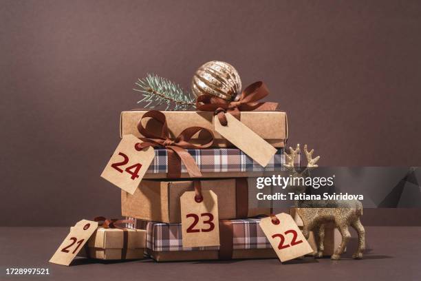 brown gift boxes with gift tag decorations and christmas tree branch - advent party stock pictures, royalty-free photos & images