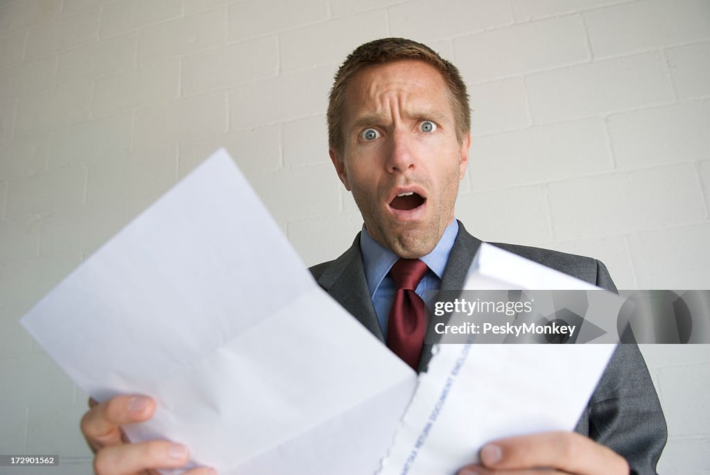 Young Man Businessman Opening Letter with Shocked Expression