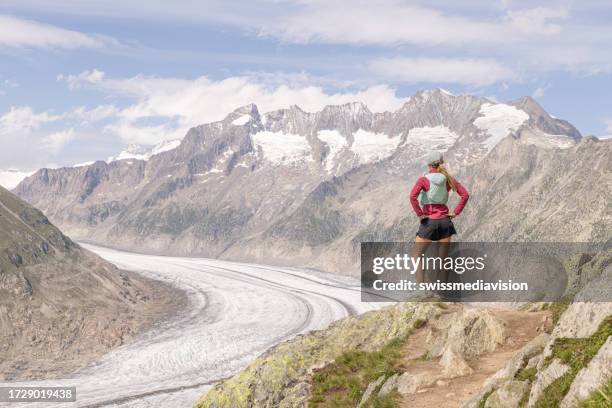 female trail runner takes a break above glacier - aletsch glacier stock pictures, royalty-free photos & images