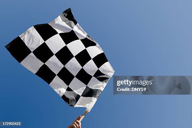 checkered flag waving against blue sky - chequered flag stock pictures, royalty-free photos & images