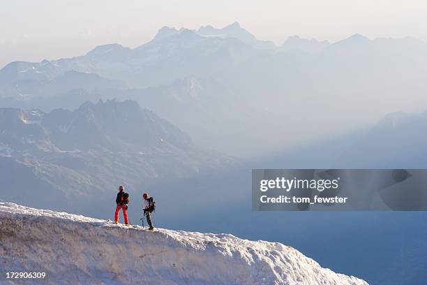 two people standing on top of an icy mountain top - aiguille du midi stock pictures, royalty-free photos & images