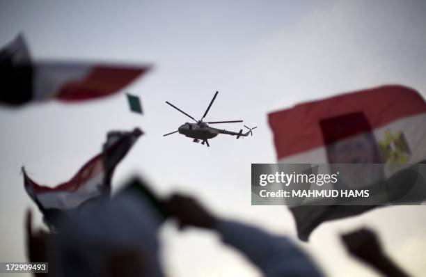 An Egyptian military helicopter hovers over supporters of the Muslim Brotherhood during a rally in support of deposed president Mohamed Morsi outside...