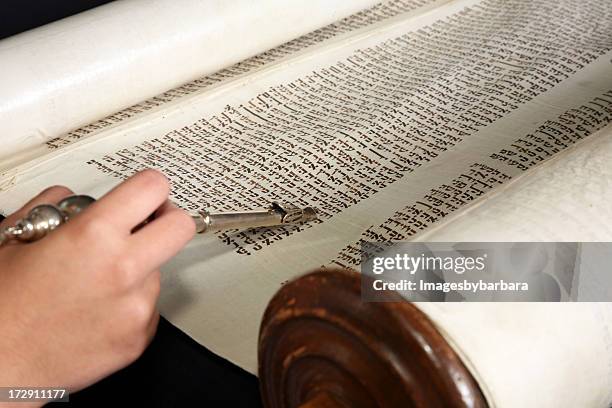 human hand with a yad touching the torah. - torah stockfoto's en -beelden