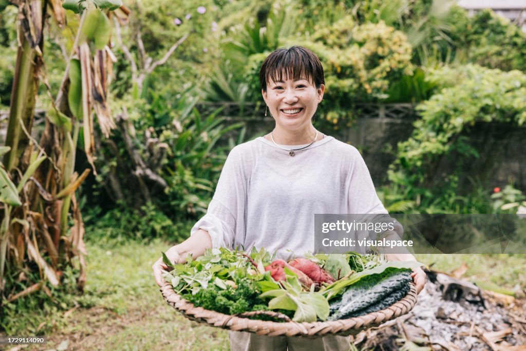 Donna giapponese con le colture fresche dal suo giardino
