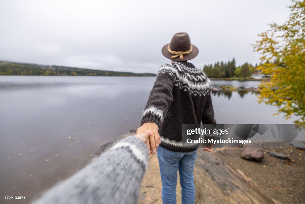 Man leading person, follow me to concept, nature in autumn
