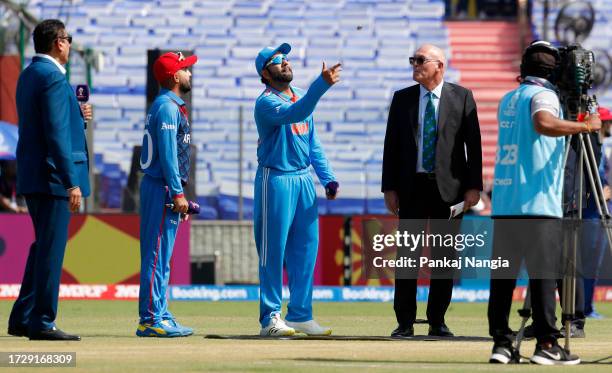 Rohit Sharma of India flips the coin as Hashmatullah Shahidi of Afghanistan looks on ahead of the ICC Men's Cricket World Cup India 2023 between...