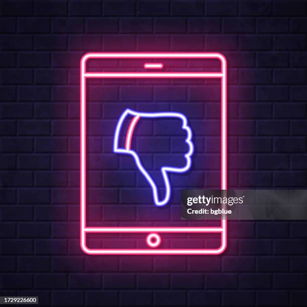 tablet pc with thumbs down. glowing neon icon on brick wall background - touch screen wall stock illustrations