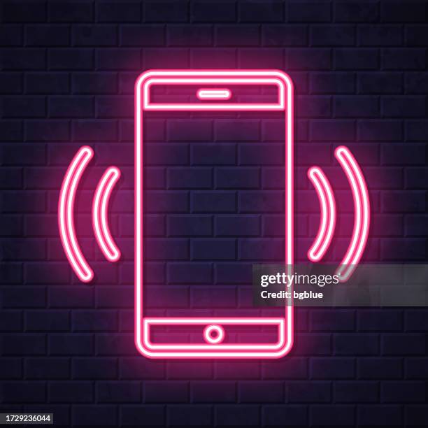 mobile phone ringing. glowing neon icon on brick wall background - iphone notification stock illustrations