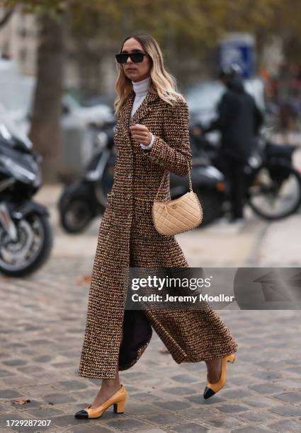 Candela Pelizzais seen outside Chanel show wearing black Chanel sunnies, white shirt underneath, beige and black checkered Chanel coat, black and...