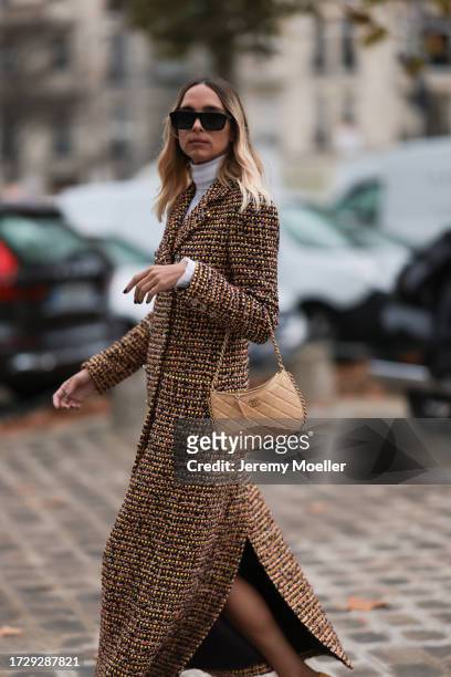 Candela Pelizzais seen outside Chanel show wearing black Chanel sunnies, white shirt underneath, beige and black checkered Chanel coat, black and...