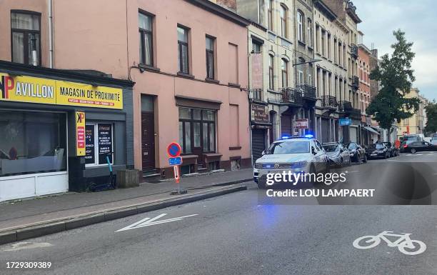 Police car drives near the Eugene Verboekhovenplein in the Schaerbeek area of Brussels on October 17 where the suspected perpetrator of the attack in...