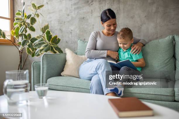 babysitter reading a book to a boy she's taking care of - children's literature stock pictures, royalty-free photos & images