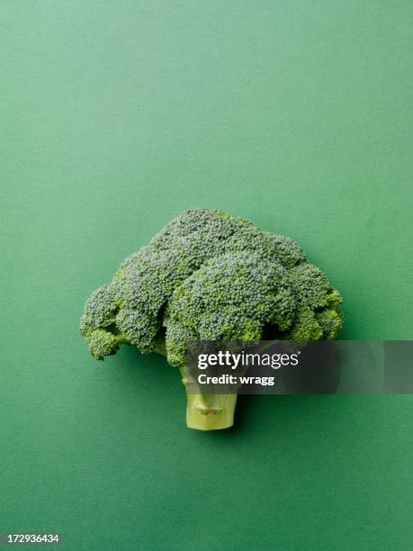 broccoli on a green background - broccoli stock pictures, royalty-free photos & images