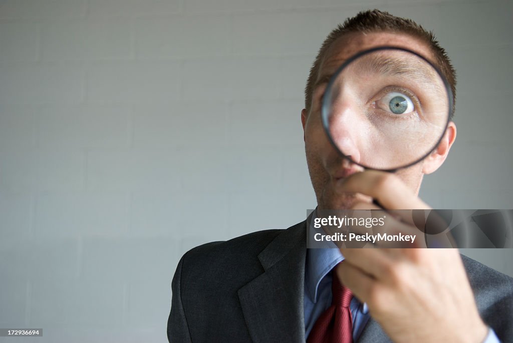 Businessman Looking Surprised with Magnifying Glass