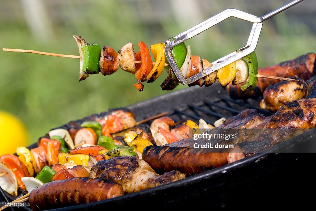 Taking vegetable kabob off the grill while the meats cook