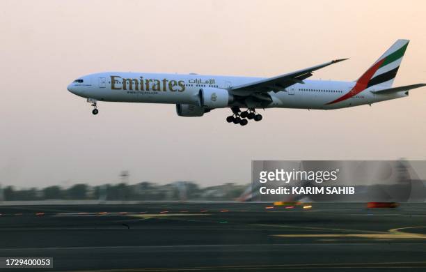 An Emirates Airlines plane lands at Dubai International Airport in Dubai on October 17, 2023.