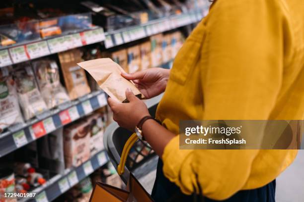 an unrecognizable woman shopping at the supermarket - paper product stockfoto's en -beelden