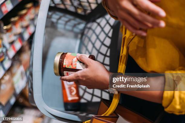 una donna irriconoscibile che fa la spesa al supermercato - marmellata foto e immagini stock