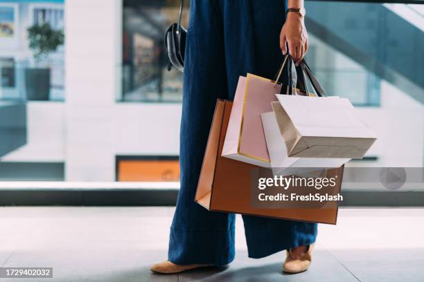 an unrecognizable beautiful woman holding her shopping bags - retail bildbanksfoton och bilder