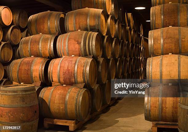 wine barrels in winery cellar of napa valley california - wine barrel stock pictures, royalty-free photos & images